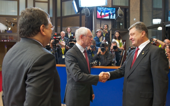 Petro Poroshenko (rechts), president van Oekraïne, schudt bij de ondertekening van het samenwerkingsakkoord met de EU de hand van EU-president Herman Van Rompuy, onder toeziend oog van José Manuel Barroso, voorzitter van de Europese Commissie