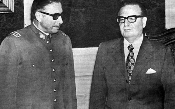 President Salvador Allende stelt generaal Augusto Pinochet voor, die hij zonet heeft benoemd tot opperbevelhebber van de Chileense strijdkrachten. Pinochet heeft de plannen voor de staatsgreep op 11 september 1973, nauwelijks enkele weken na zijn benoeming, al op zak