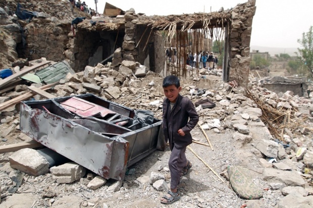 Een Jemenitisch jongetje loopt door de ruïnes van zijn dorp
