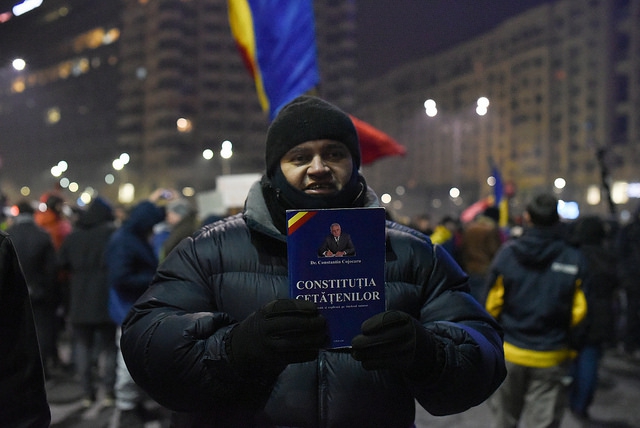 Tijdens een protestactie aan het ministerie van justitie op 31 januari 2017 houdt deze betoger een exemplaar van de Roemeense Grondwet voor zich 