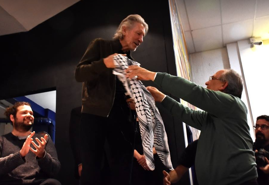 Walid Abdel Rahim, ambassadeur van Palestina in Uruguay, overhandigt een keffiyeh