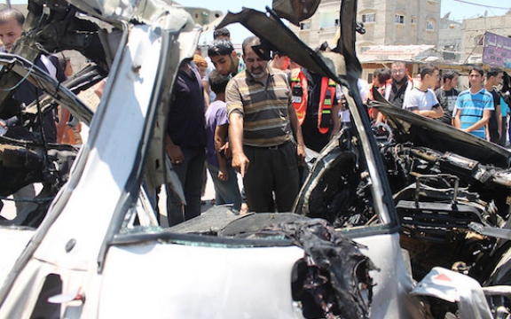 Personeel van de civiele bescherming controleert een auto na een bomaanslag met drie slachtoffers op 10 juli 2014. (82 en 83 op de lijst. De derde dode werd niet geïdentificeerd)