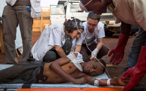 Een gewonde man krijgt verzorging van een medewerker van Artsen Zonder Grenzen in het kamp Mpoko